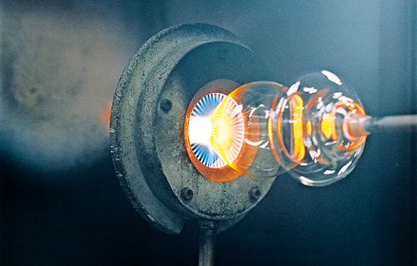 Du verre liquide est façonné à l'aide d'une canne dans un atelier de soufflage de verre.