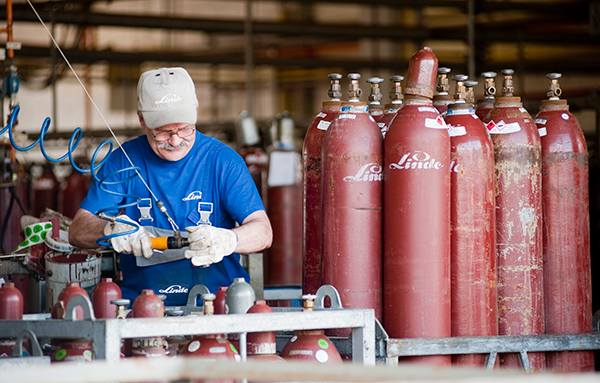 Employee inspects acetylene gas cylinder