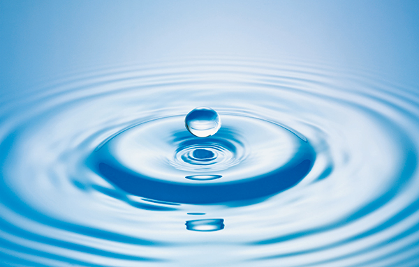 Gros plan d'une goutte d'eau au-dessus de la surface de l'eau en mouvement