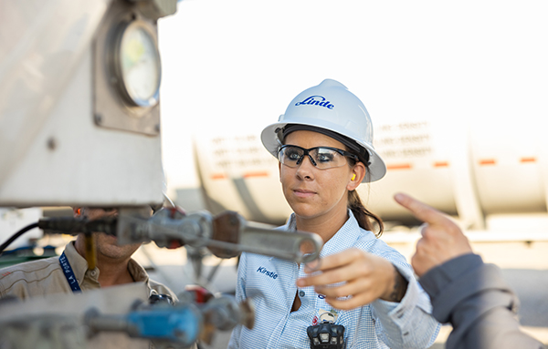 Mitarbeiterin mit Helm bei Kontrolle einer Gasanlage