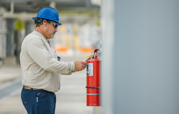 Mann kontrolliert Feuerlöscher