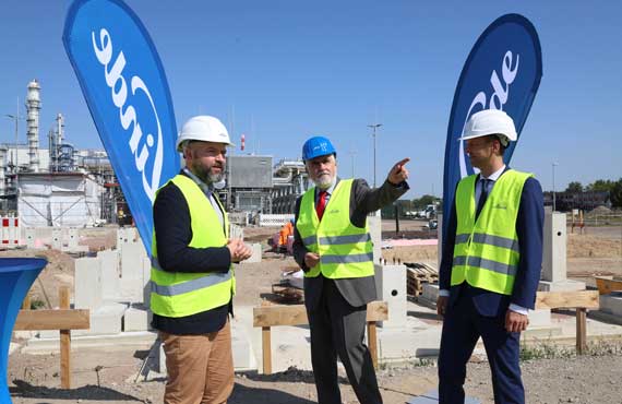 Gruppenbild mit 3 Personen vor Baugrube