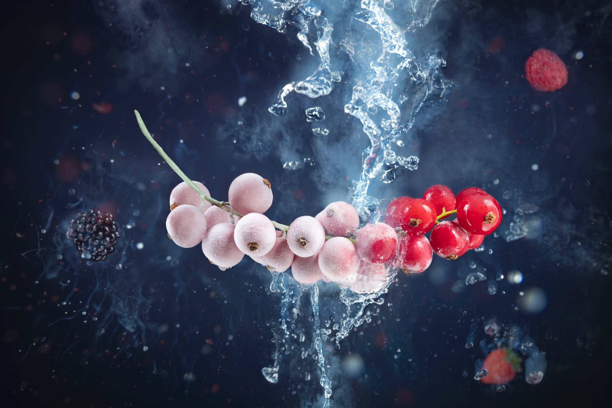 Frutti congelati immersi in acqua con schizzi dinamici su sfondo scuro