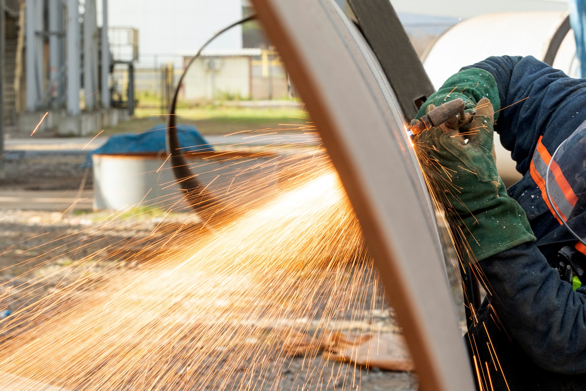 High-temperature acetylene flame cutting through metal with sparks flying